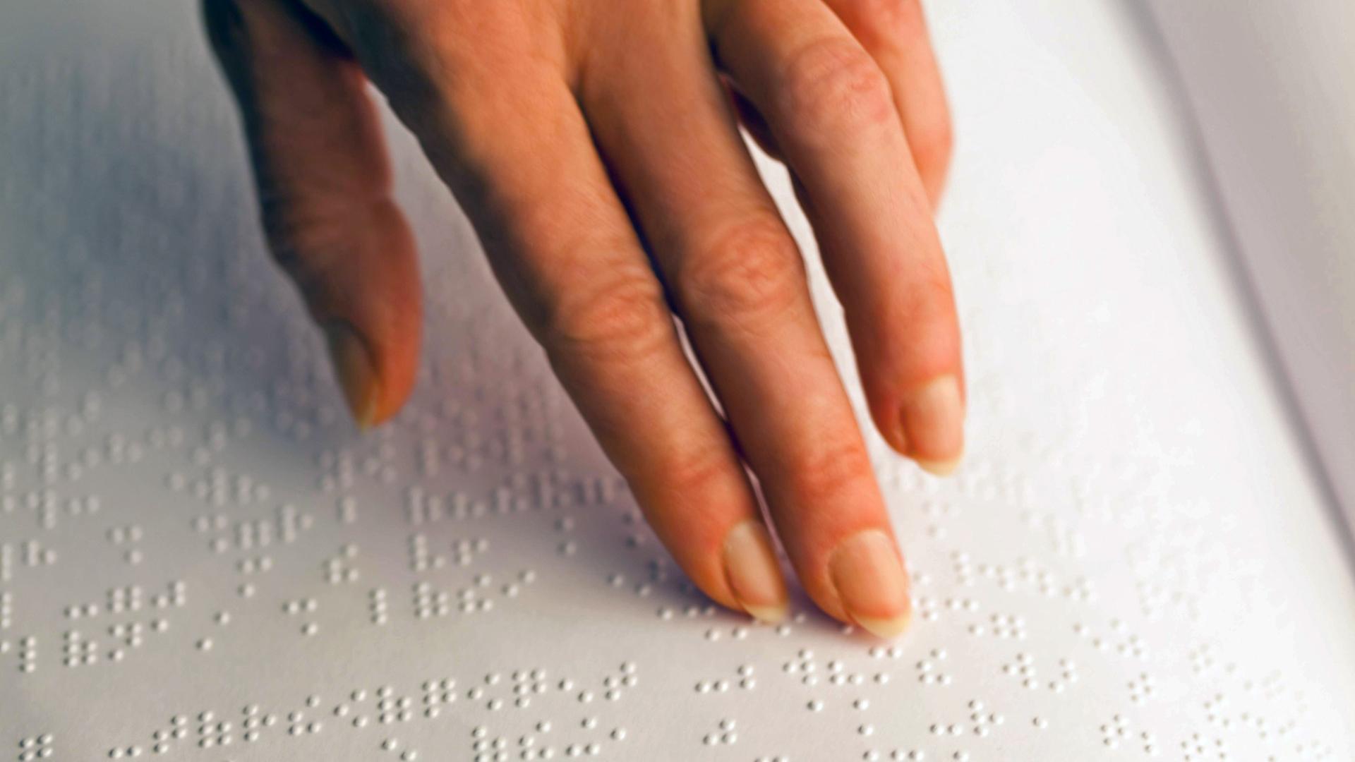 Eine blinde Frau liest ein Buch in Brailleschrift. Eine blinde Frau liest ein Buch in Brailleschrift.