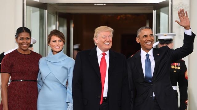 Die Obamas und die Trumps strahlend vor einem Eingang.