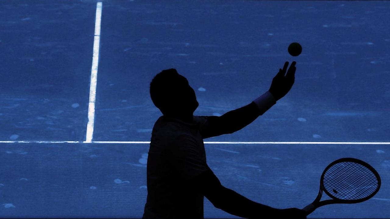 Ein Tennisspieler schlägt vor dem Netz mit der Aufschrift "ATP World Tour" in Madrid auf. Ein Tennisspieler schlägt vor dem Netz mit der Aufschrift "ATP World Tour" in Madrid auf.