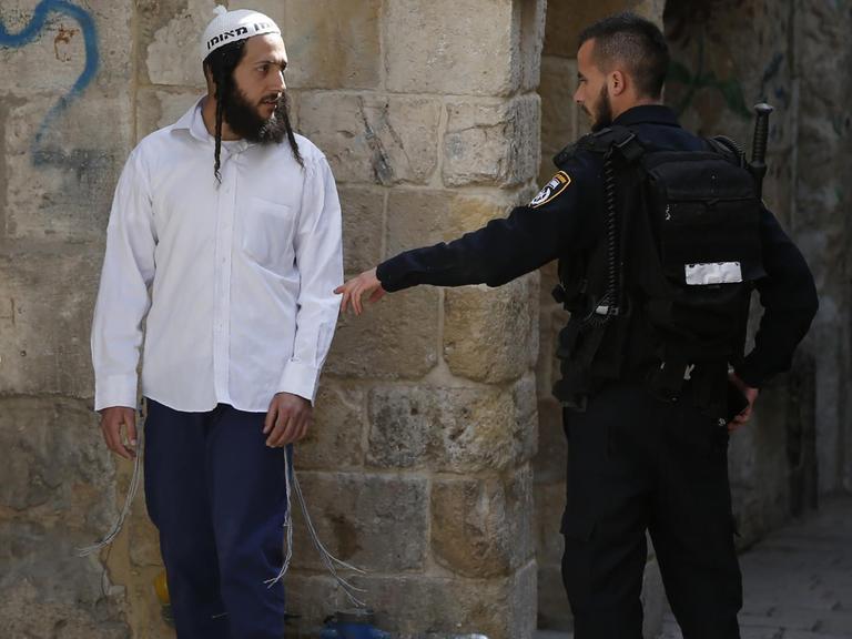 Ein israelischer Sicherheitsmann verweist einen jüdischen Besucher vor die Tür, nachdem dieser in der Al-Aqsa-Moschee ein jüdisches Gebet gesprochen hat, was dort verboten ist.