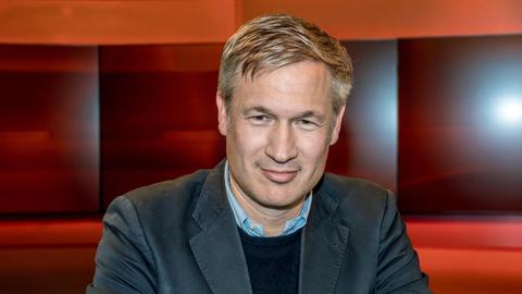 Ulf Poschardt, Chefredakteur der "Welt"-Gruppe, vor einem roten Hintergrund, im Fernsehstudio der Sendung "Hart aber fair.