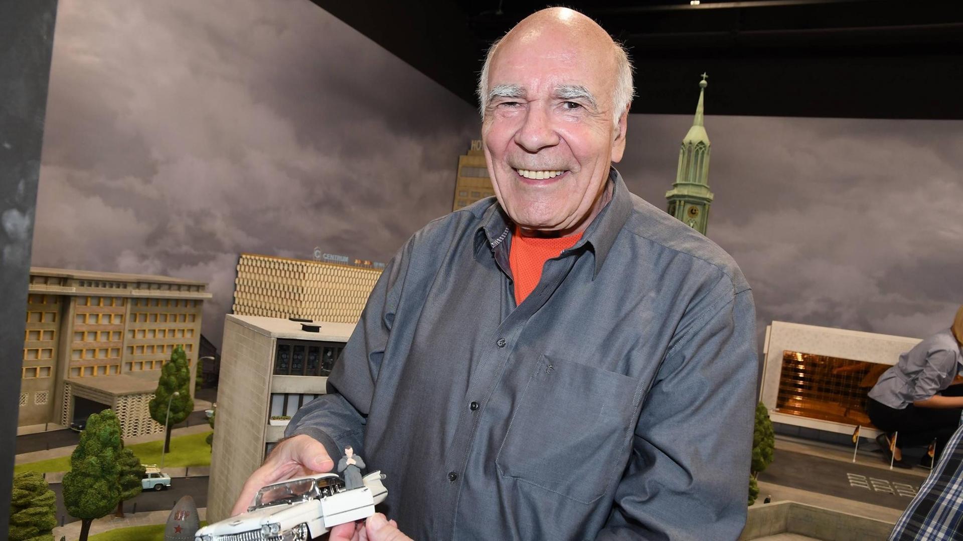 Burkhard Veigel hält in der Hand ein Modellauto und schau in die Kamera. Burkhard Veigel hält in der Hand ein Modellauto und schau in die Kamera.