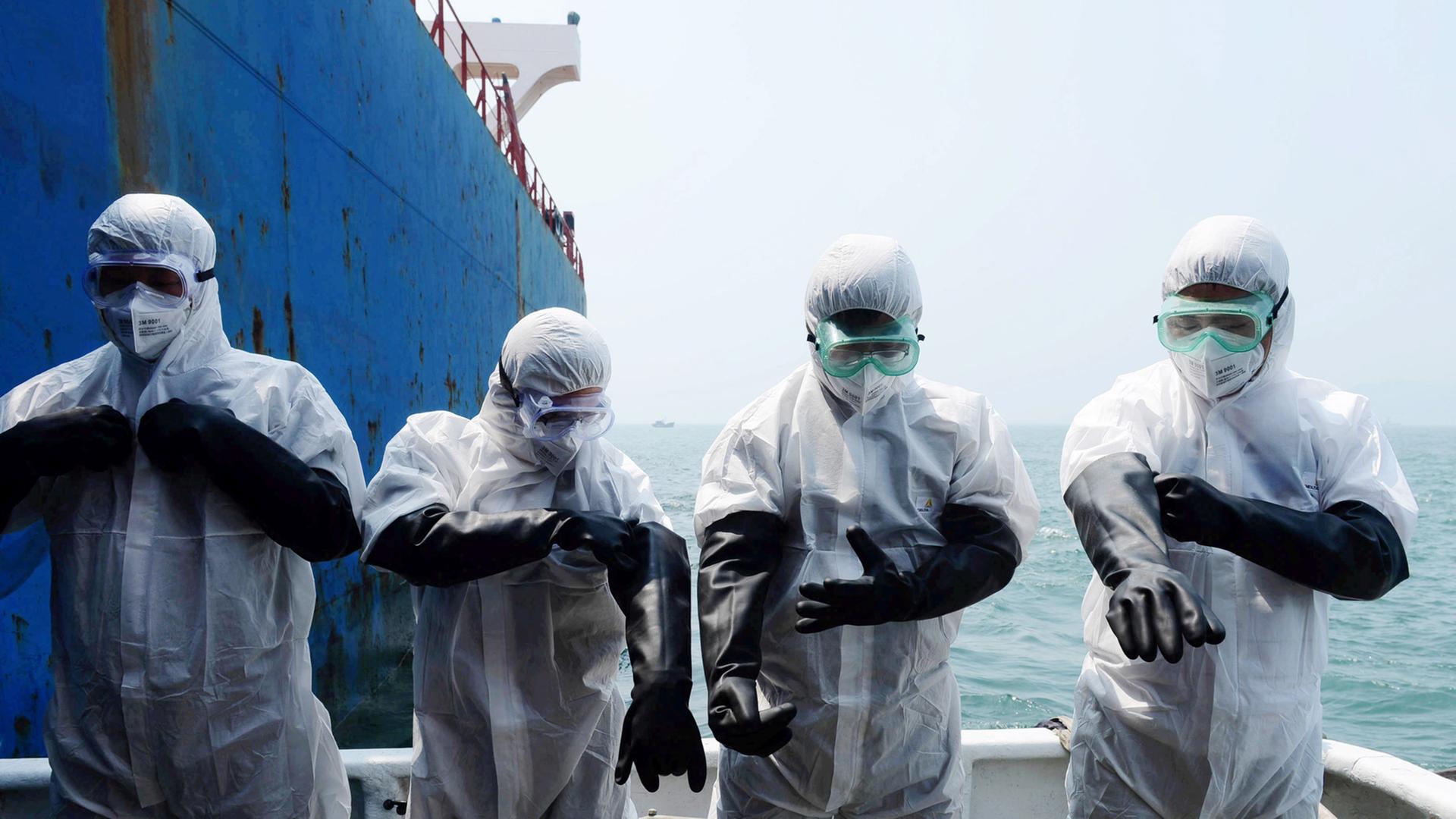 Chinesische Quarantäne-Arbeiter inspizieren ein Schiff aus Sierra Leone Chinesische Quarantäne-Arbeiter inspizieren ein Schiff aus Sierra Leone