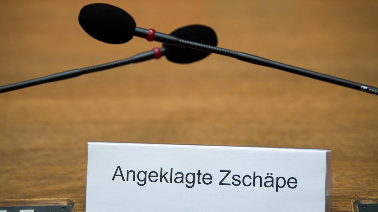 Ein Schild mit der Aufschrift «Angeklagte Zschäpe» steht am 01.09.2017 auf der Anklagebank im Gerichtssaal im Oberlandesgericht in München (Bayern). Mit im Bild: zwei Mikrofone. Ein Schild mit der Aufschrift «Angeklagte Zschäpe» steht am 01.09.2017 auf der Anklagebank im Gerichtssaal im Oberlandesgericht in München (Bayern). Mit im Bild: zwei Mikrofone.