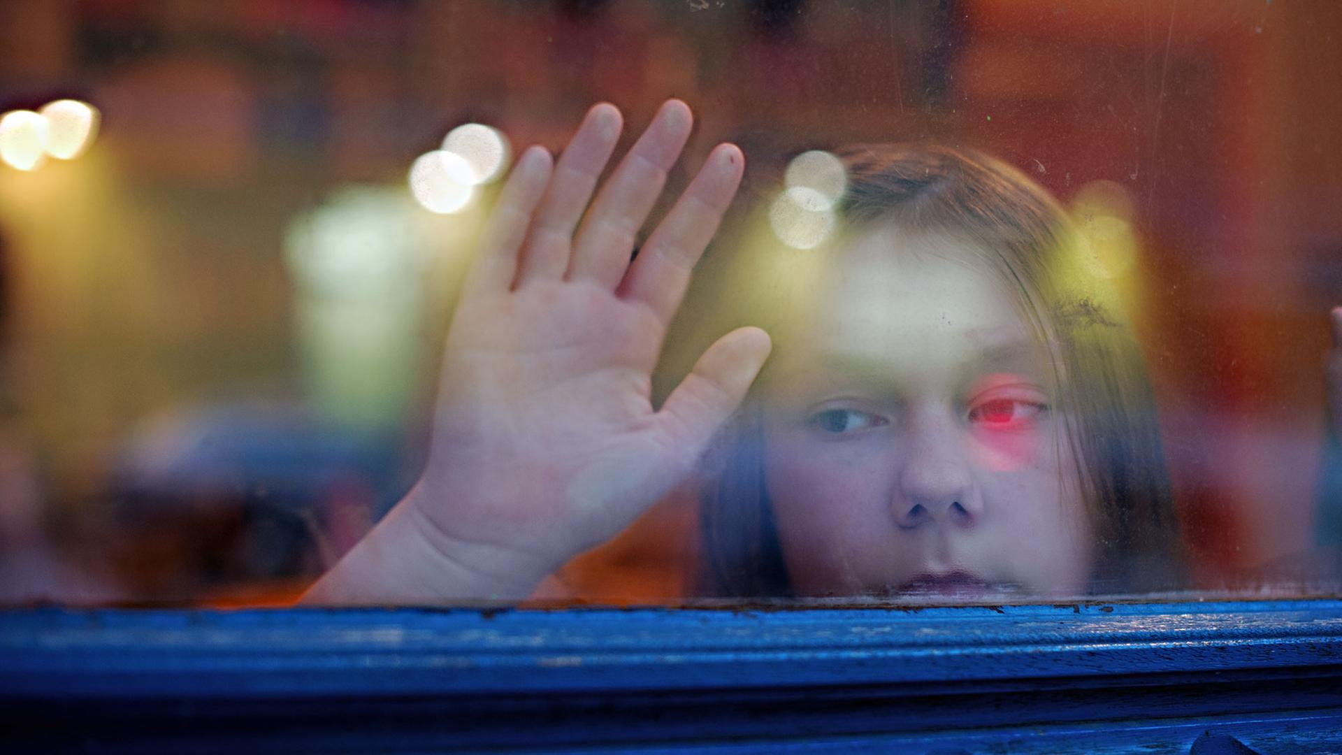 Ein junges Mädchen blickt am 24.01.2014 in Berlin aus einem Fenster. Ein junges Mädchen blickt am 24.01.2014 in Berlin aus einem Fenster.