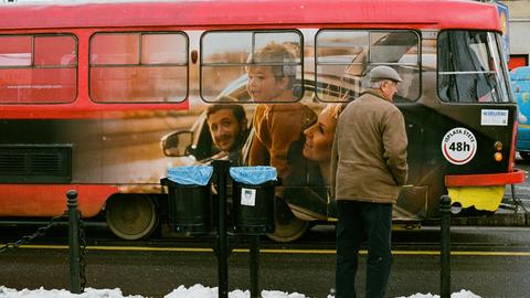 Ein Bus mit einer Familien-Reklame auf der Seite fährt durchs Bild