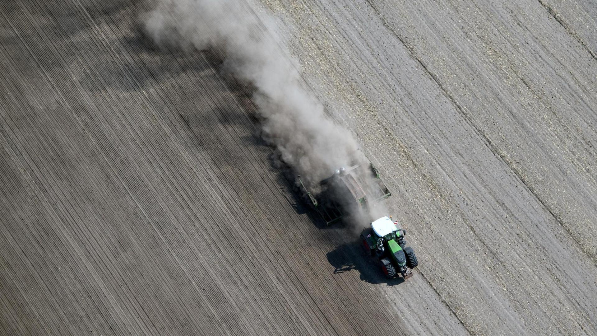 Eine dichte Staubwolke zieht ein Traktor bei Feldarbeiten in Schönhagen in Brandenburg hinter sich her, aufgenommen im August 2018 Eine dichte Staubwolke zieht ein Traktor bei Feldarbeiten in Schönhagen in Brandenburg hinter sich her, aufgenommen im August 2018