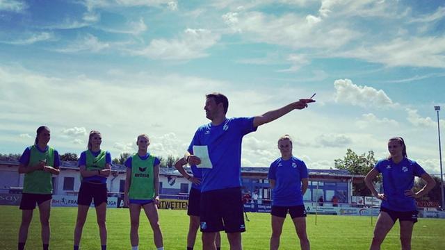Der Sportdirektor des SC Sand, Sascha Reiß, spricht zu seinen Spielerinnen auf dem Trainingsgelände.