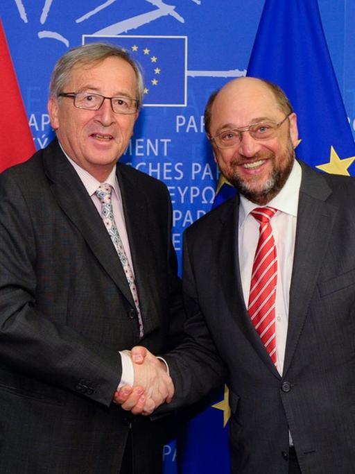 Jean-Claude Juncker und Martin Schulz schütteln sich die Hände