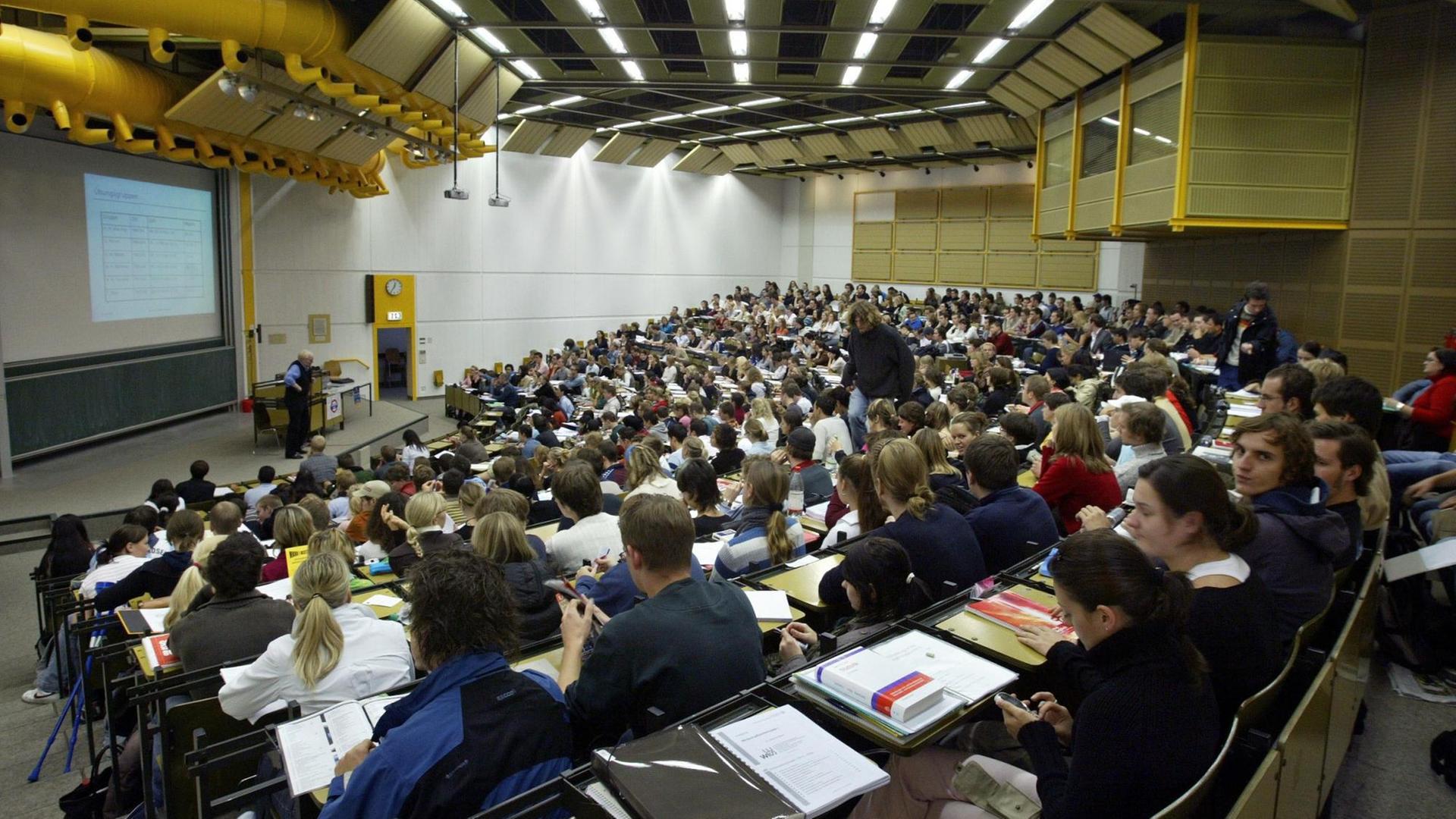 Studenten sitzen während einer Volkswirtschafts-Vorlesung im großen Hörsaal der Universität Augsburg. Studenten sitzen während einer Volkswirtschafts-Vorlesung im großen Hörsaal der Universität Augsburg.