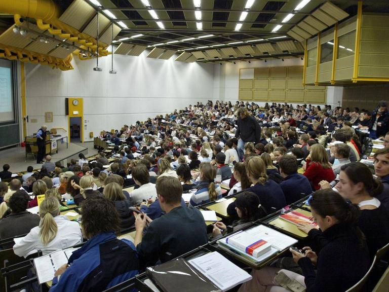 Studenten sitzen in einem großen Hörsaal.