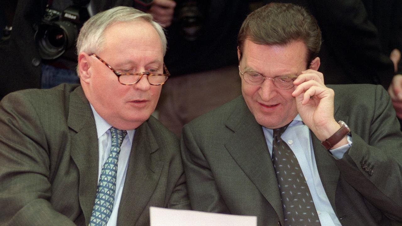 Bundeskanzler Gerhard Schröder (r.) und Finanzminister Oskar Lafontaine wenden sich ihren Unterlagen zu; Aufnahme vom Dezember 1998 Bundeskanzler Gerhard Schröder (r.) und Finanzminister Oskar Lafontaine wenden sich ihren Unterlagen zu; Aufnahme vom Dezember 1998