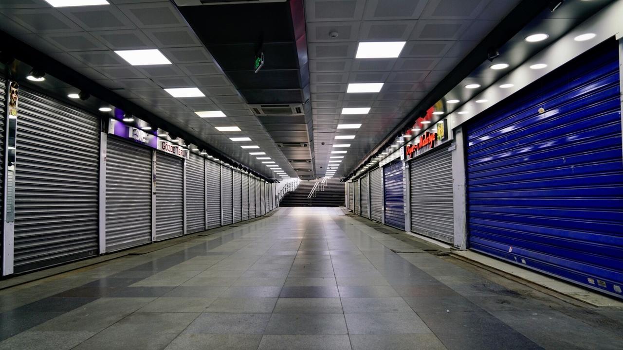 Eine gähnend leere Unterführung umrahmt von Läden mit heruntergelassen Läden. Am Ende führt eine - leere - Treppe nach oben.