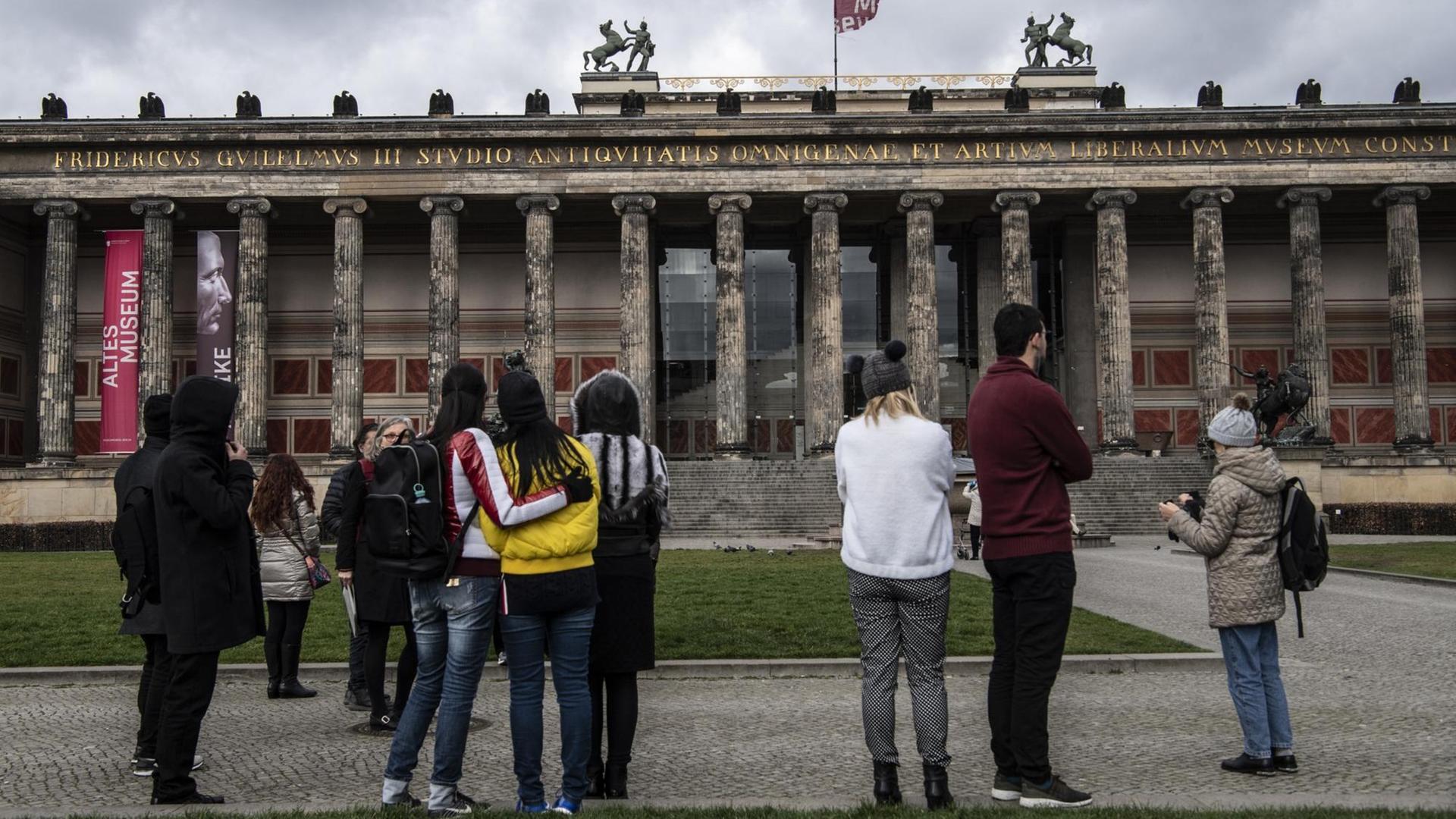 Passanten stehen vor dem Eingang des geschlossenen Alten Museums in Berlin.