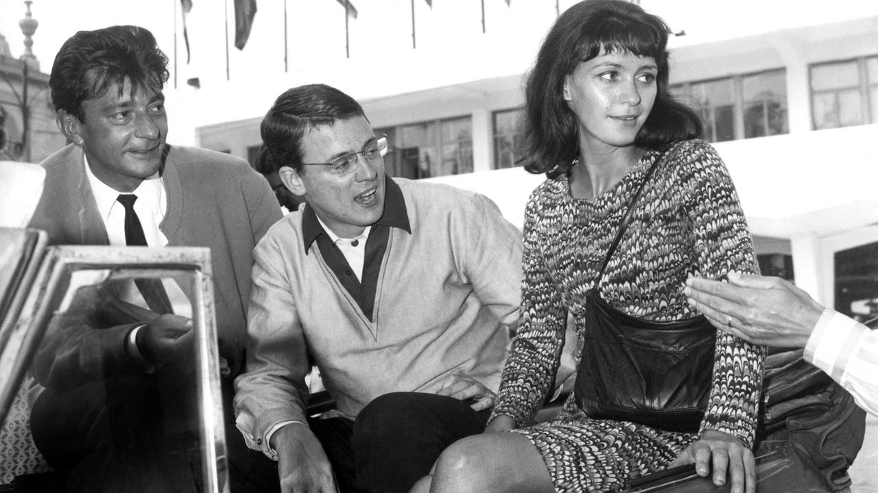 Der Regisseur des Films "Abschied von gestern" Alexander Kluge (M), der Drehbuchautor Günther Mack (l) und die Schauspielerin Alexandra Kluge (r) in einem Cabrio während des Filmfestivals in Venedig 1966. Der Regisseur des Films "Abschied von gestern" Alexander Kluge (M), der Drehbuchautor Günther Mack (l) und die Schauspielerin Alexandra Kluge (r) in einem Cabrio während des Filmfestivals in Venedig 1966.