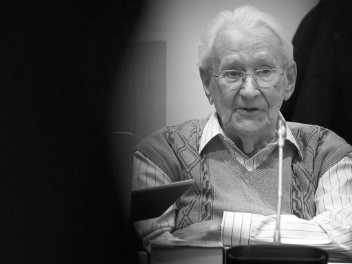 Oskar Gröning sitzt mit verschränkten Armen auf der Anklagebank.