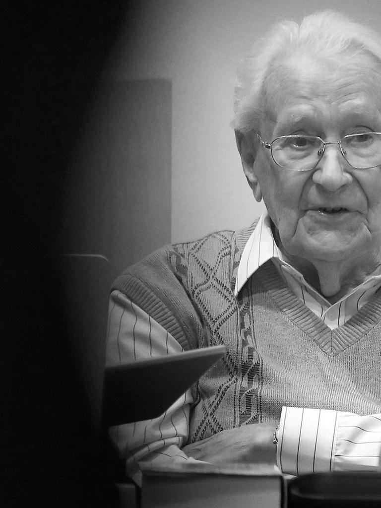 Oskar Gröning sitzt mit verschränkten Armen auf der Anklagebank.