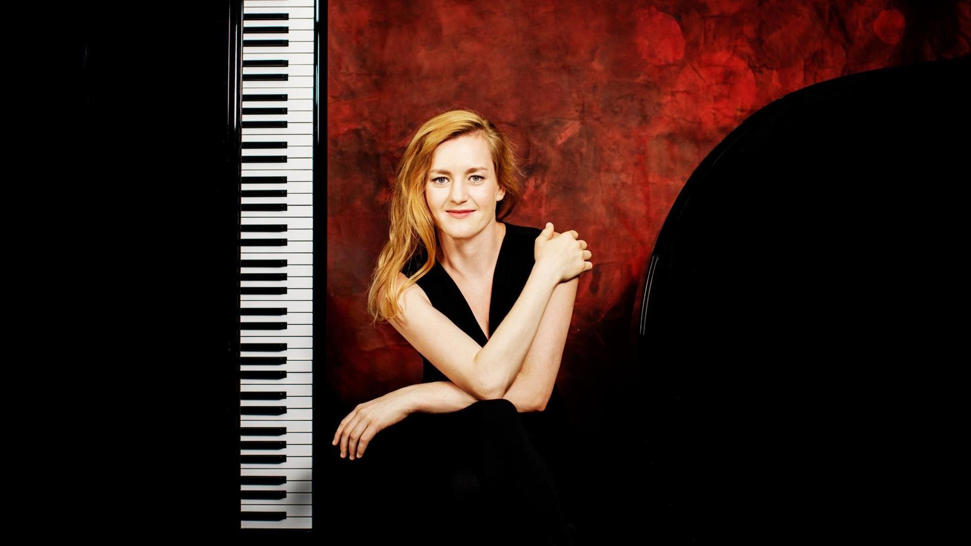 Die Pianistin sitzt naben eine hochkant aufgestellten Klaviatur. Die Pianistin sitzt naben eine hochkant aufgestellten Klaviatur.