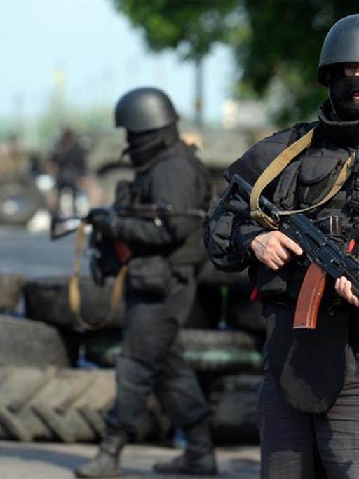 Ukrainische Soldaten an einem Checkpoint in der Nähe von Slawjansk, im Hintergrund Reifen