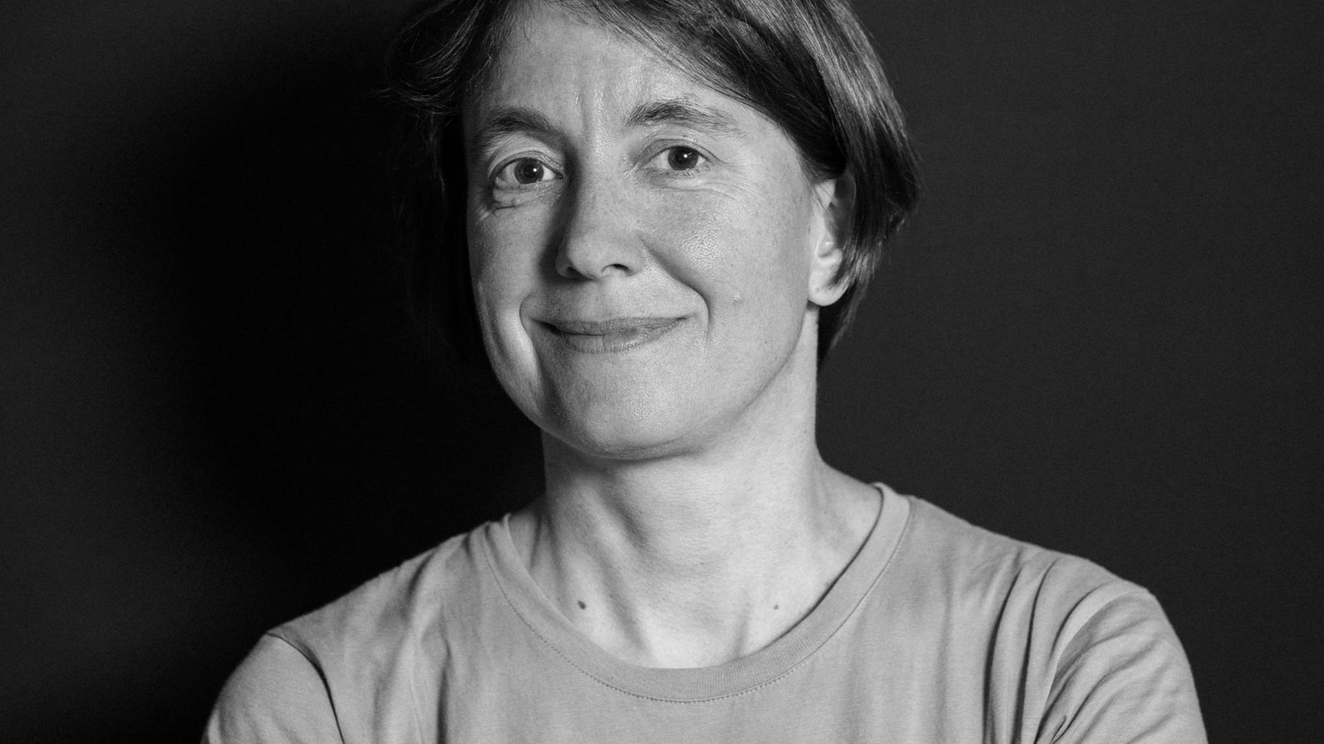 Kathrin Passig steht vor einer dunklen Wand und schaut freundlich in die Kamera. Kathrin Passig steht vor einer dunklen Wand und schaut freundlich in die Kamera.