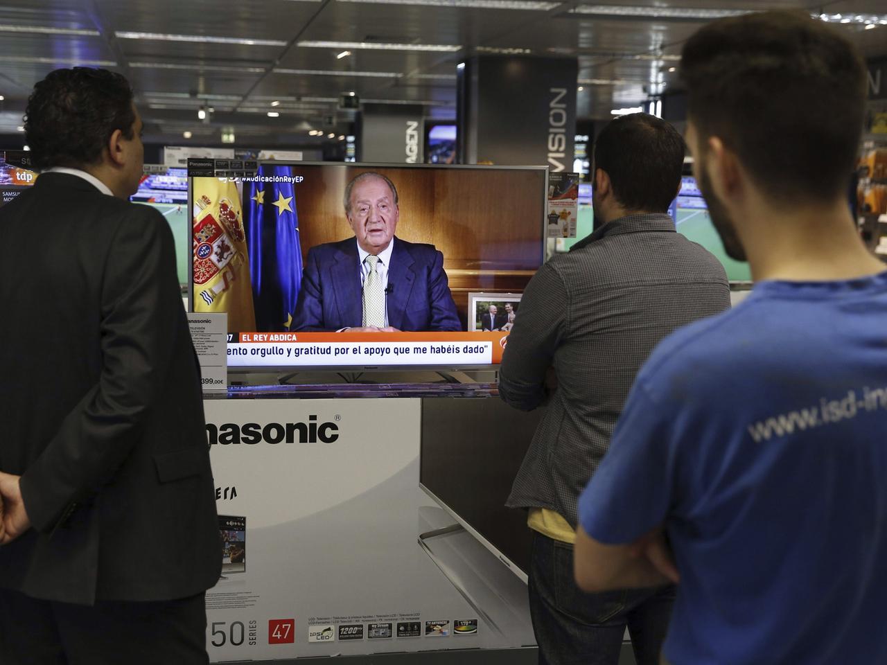 Spanier verfolgen die Fernsehansprache von König Juan Carlos, in denen er die Gründe für seine Abdankung nennt.