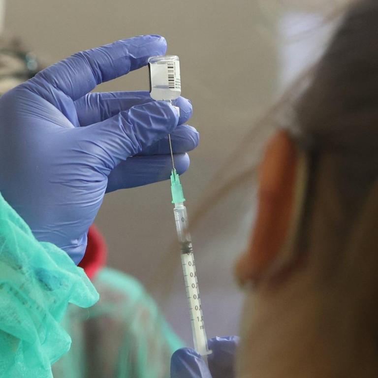 Eine Krankenschwester zieht den Covid-19 Pfizer-Biontech Impfstoff in eine Spritze auf.