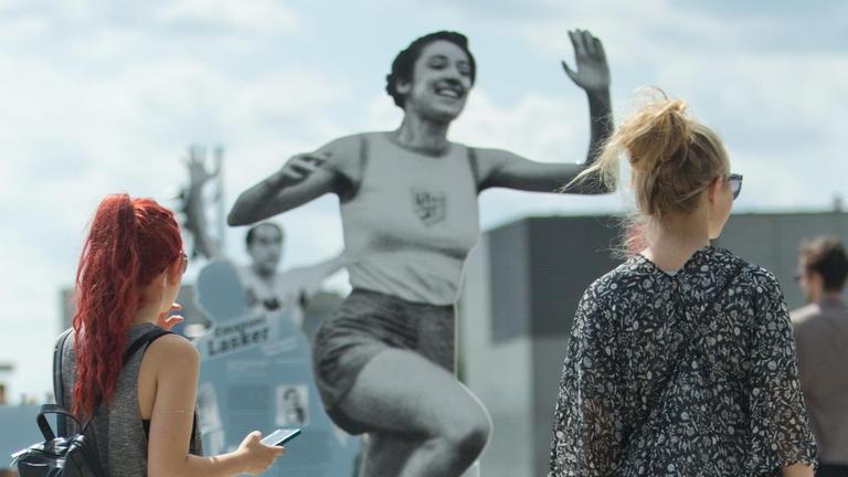 Zwei Frauen betrachten die Skulptur der Leichtathletin Gretel Bergmann.