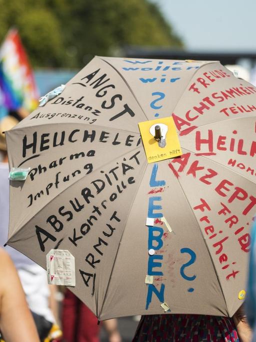 Anti-Corona-Demonstration in Berlin. Auf einem Schirm steht u. a.: "Wie wollen wir leben?"