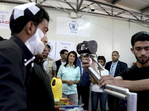 Die US-Botschafterin bei den Vereinten Nationen, Nikki Haley (Hintergrund), beobachtet, wie ein bandagierter syrischer Flüchtling seine Iris am 21. Mai 2017 im Zaatari Flüchtlingslager in einem Supermarkt gescannt hat.