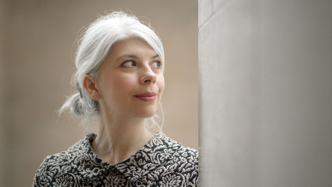 Die Autorin Marica Bodrozic mit der Blickrichtung nach rechts hinter eine graue Wand.
