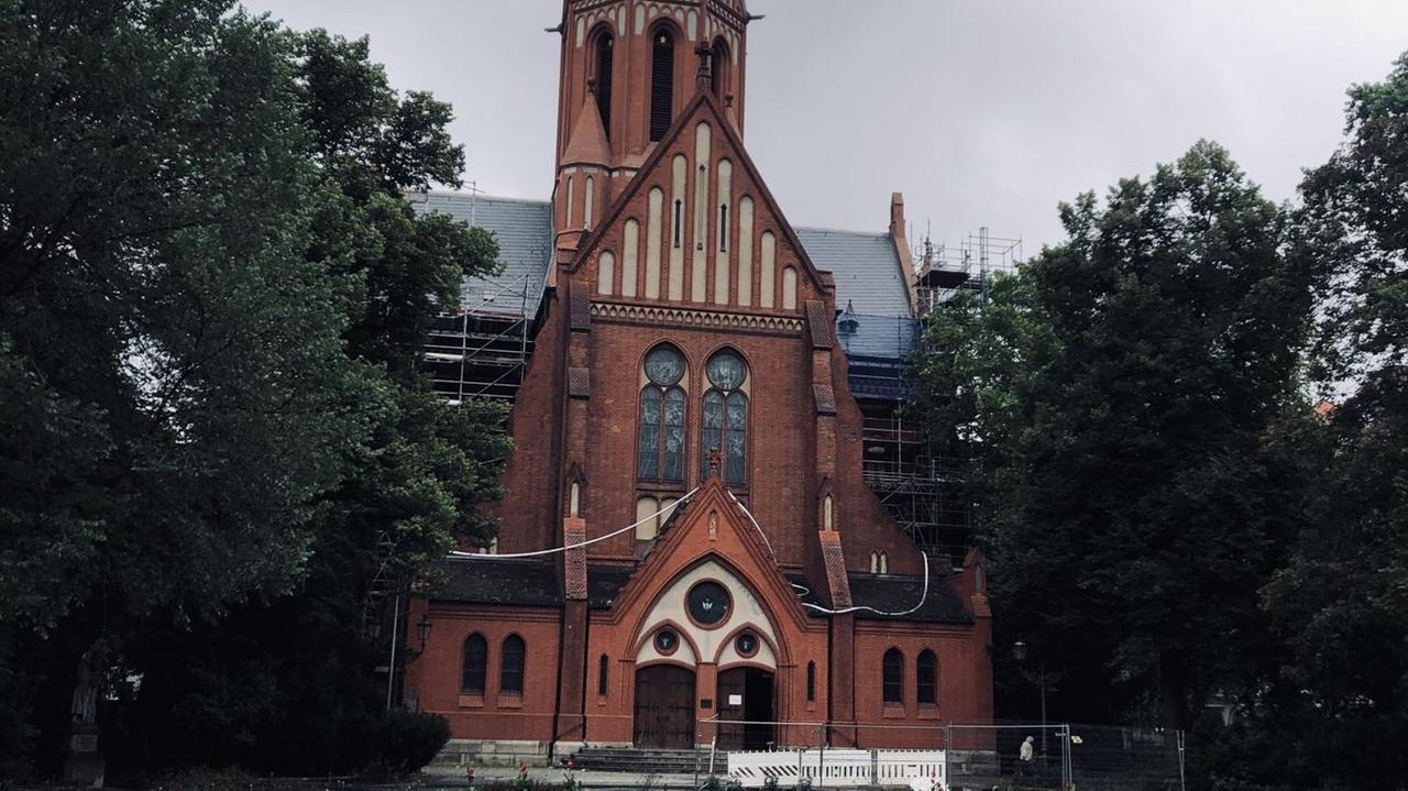 Die Kirche St. Ludwig und ihr Vorplatz, ein Fußweg, umsäumt von Rasenflächen, führt auf das Portal zu. Die Kirche St. Ludwig und ihr Vorplatz, ein Fußweg, umsäumt von Rasenflächen, führt auf das Portal zu.
