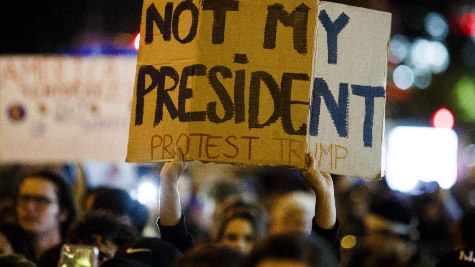 Ein Demonstrant in New York hält ein Schild mit der Aufschrift "Nicht mein Präsident" hoch. Ein Demonstrant in New York hält ein Schild mit der Aufschrift "Nicht mein Präsident" hoch.
