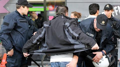 Nach Auseinandersetzungen zwischen Kurden und Salafisten kontrollieren Polizisten in Hamburg eine Personengruppe.
