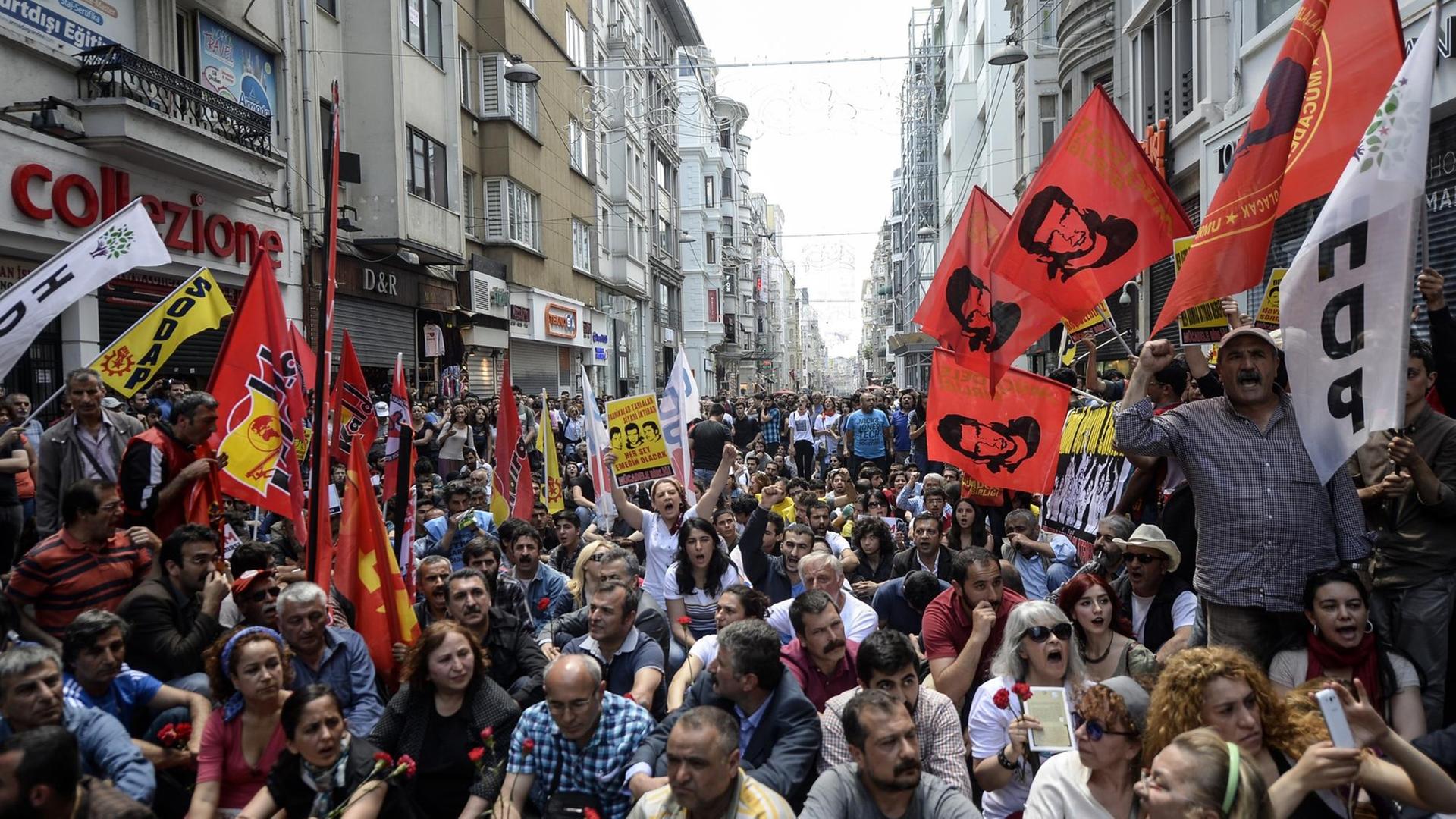 Eine Menschenmenge sitzt und steht auf einer engen Einkaufsstraße in Istanbul. Eine Menschenmenge sitzt und steht auf einer engen Einkaufsstraße in Istanbul.