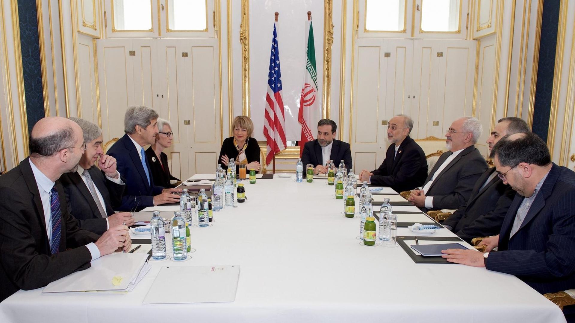 US-Außenminister Kerry und sein iranischer Amtskollege Sarif sitzen am 30. Juni in Wien gemeinsam mit zahlreichen weiteren Delegationsmitgliedern an einem Tisch. US-Außenminister Kerry und sein iranischer Amtskollege Sarif sitzen am 30. Juni in Wien gemeinsam mit zahlreichen weiteren Delegationsmitgliedern an einem Tisch.