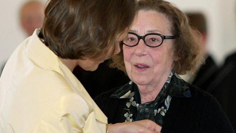 Am 4.10.2002 steckt Christina Rau, Ehefrau des Bundespräsidenten Johannes Rau, der Sopranistin Agnes Giebel im Schloss Bellevue in Berlin das Bundesverdienstkreuz an. Am 4.10.2002 steckt Christina Rau, Ehefrau des Bundespräsidenten Johannes Rau, der Sopranistin Agnes Giebel im Schloss Bellevue in Berlin das Bundesverdienstkreuz an.