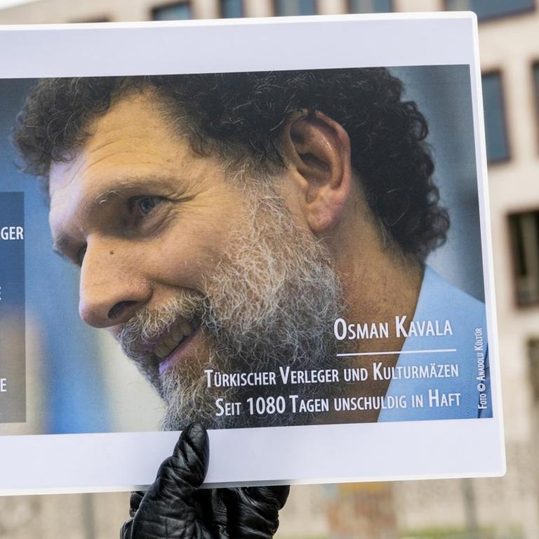 Ein Mann hält bei einer Mahnwache des PEN-Zentrums für den türkischen Verleger und Kulturmäzen Osman Kavala vor der Türkischen Botschaft ein Bild von Kavala. 