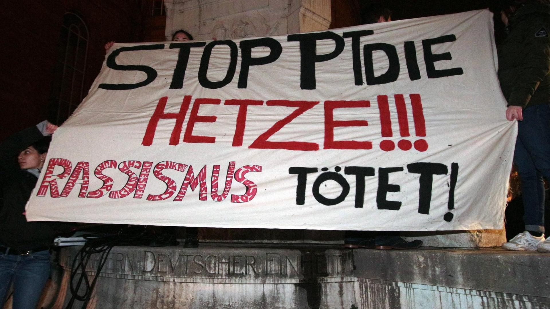 Auf einem Plakat während einer Mahnwache steht: Stoppt die Hetze! Rassismus tötet! Auf einem Plakat während einer Mahnwache steht: Stoppt die Hetze! Rassismus tötet!