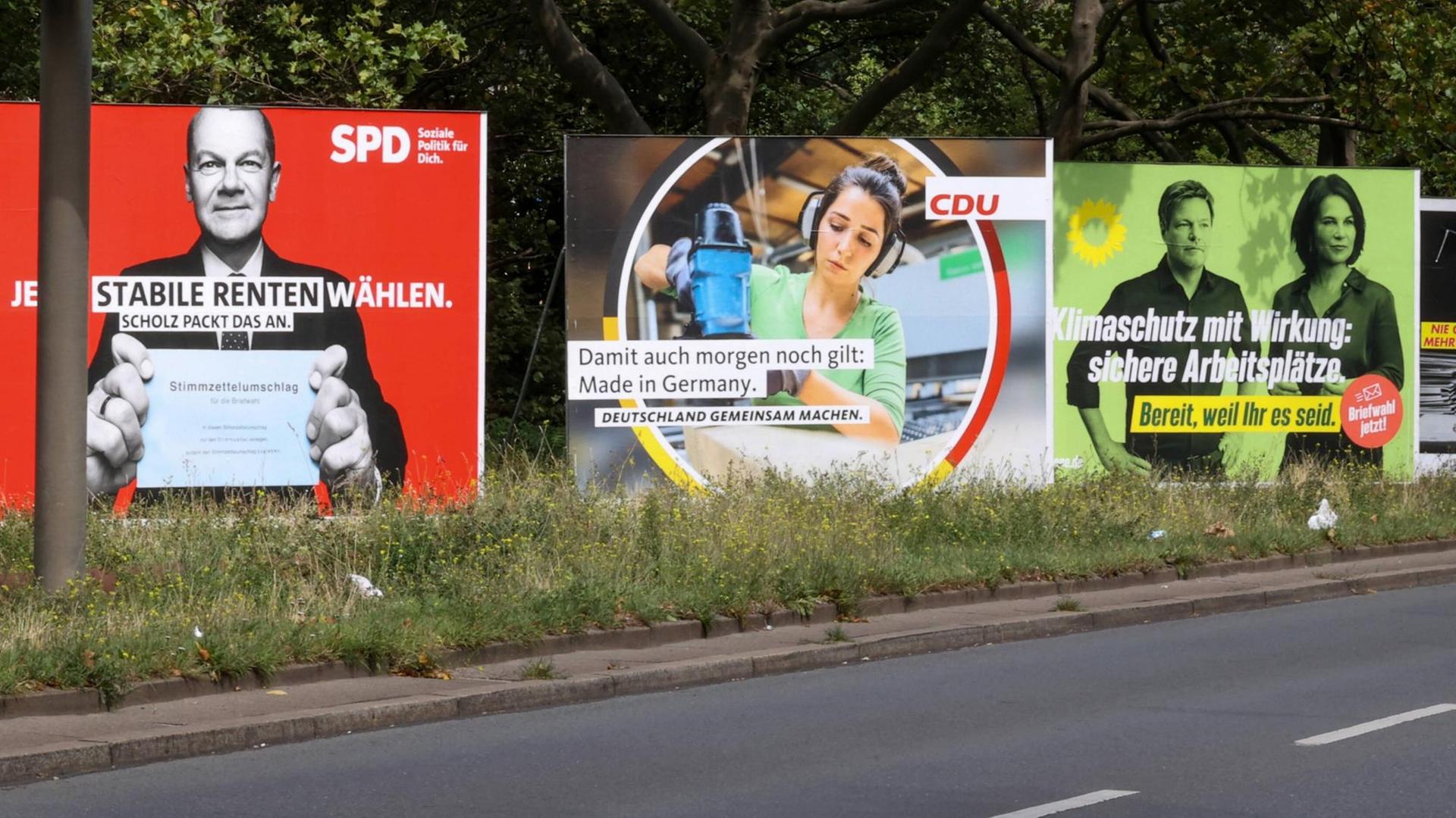 An einer Straße stehen große Wahlplakate von SPD, CDU und Grünen An einer Straße stehen große Wahlplakate von SPD, CDU und Grünen