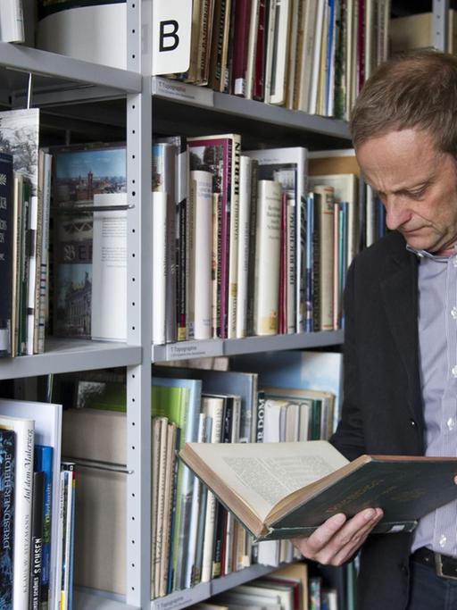 Der Leiter der Provenienzforschung, Gilbert Lupfer, schaut am 13.08.2013 in der Bibliothek der Staatlichen Kunstsammlung im Residenzschloss in Dresden (Sachsen) in ein Buch.