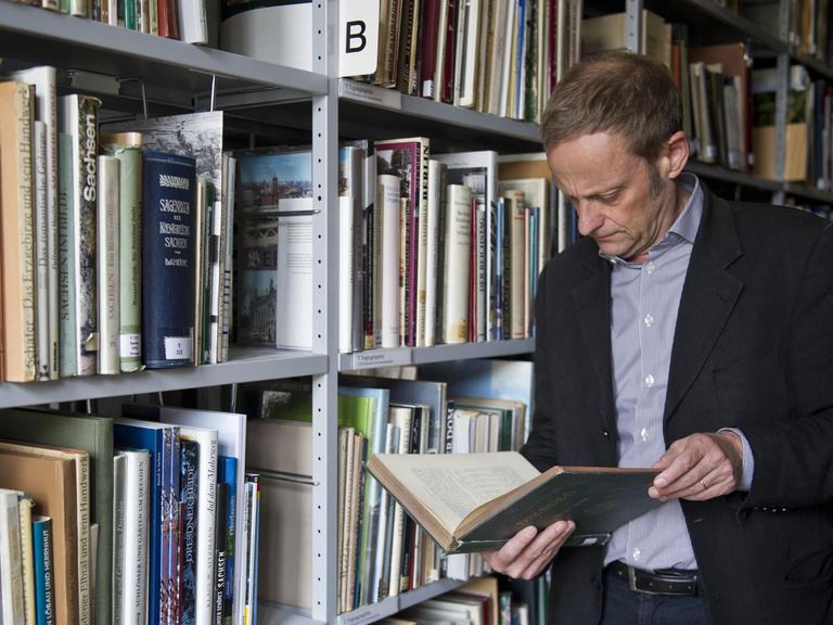 Der Leiter der Provenienzforschung, Gilbert Lupfer, schaut am 13.08.2013 in der Bibliothek der Staatlichen Kunstsammlung im Residenzschloss in Dresden (Sachsen) in ein Buch.