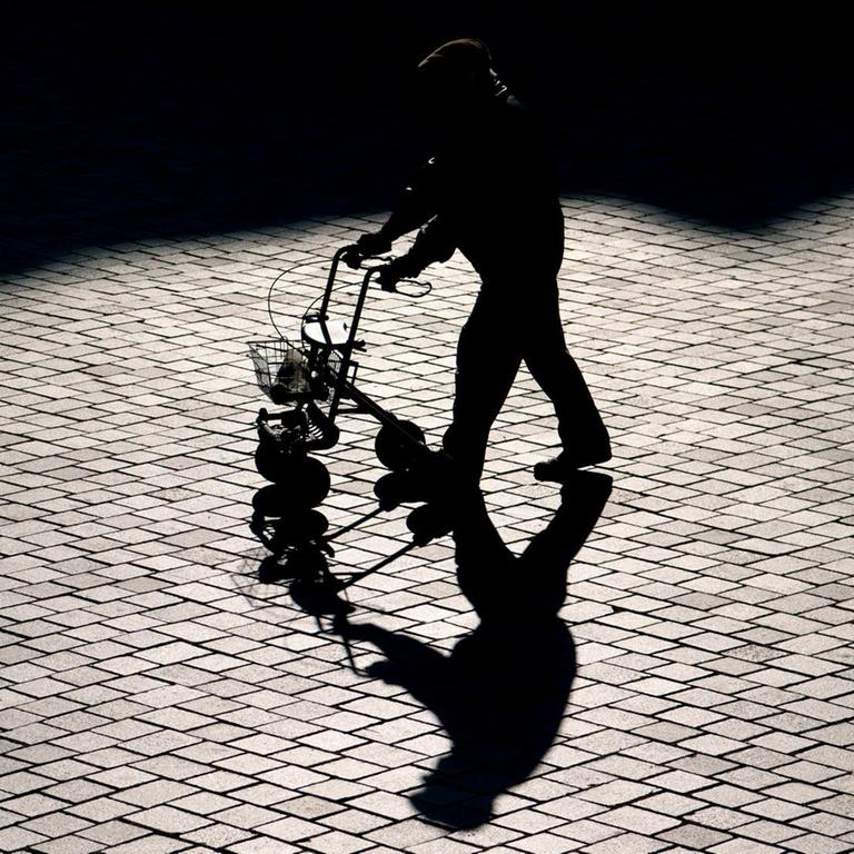 Ein Rentner ist mit einem Rollator in Potsdam unterwegs.
