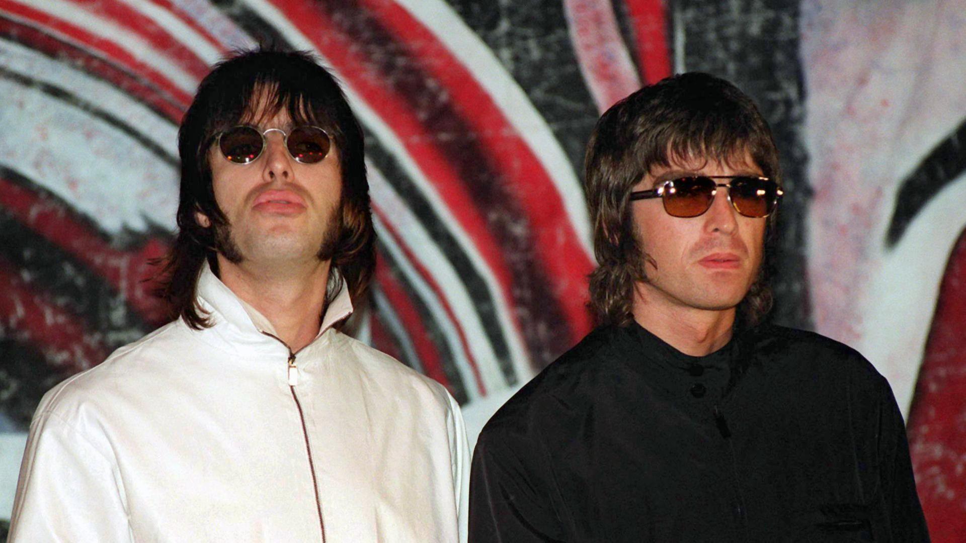 Liam (l.) und Noel Gallagher von der britischen Rockband Oasis bei einer Pressekonferenz 1999 in London.