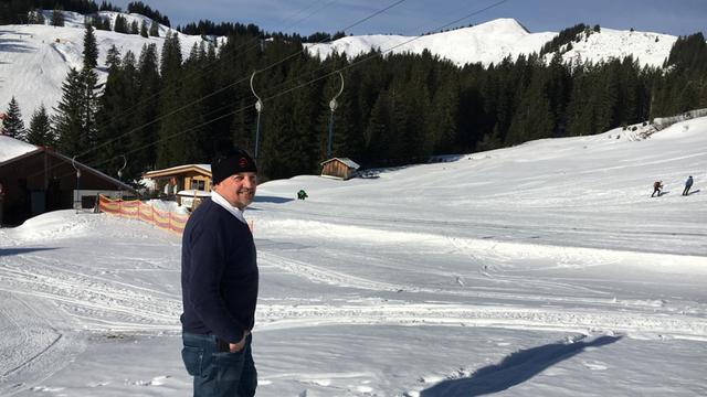 Berni Huber, Ex-Weltcupskifahrer und Geschäftsführer des Skigebiets Grasgehren, steht vor dem baumlosen Gipfel des Riedberger Horns.