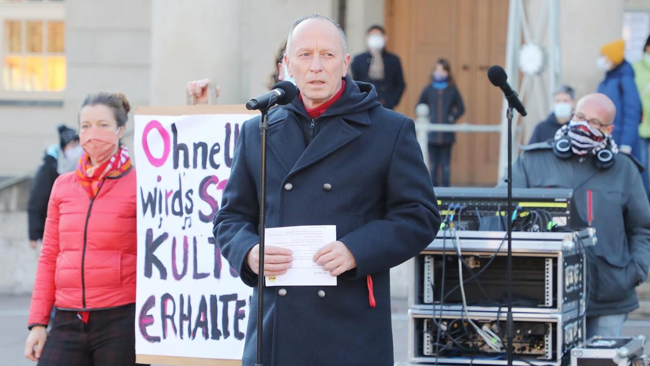 Hasko Weber, Generalintendant des Deutschen Nationaltheaters Weimar, spricht vor dem Schauspielhaus am gemeinsamen Aktionstag unter dem Motto "Wir sind da!", um in Zeiten der Corona-Pandemie Solidarität mit anderen betroffenen Einrichtungen zum Ausdruck zu bringen. Hinter ihm sind ein Techniker mit Mischpult und eine Frau, die ein Plakat hält, zu sehen. Hasko Weber, Generalintendant des Deutschen Nationaltheaters Weimar, spricht vor dem Schauspielhaus am gemeinsamen Aktionstag unter dem Motto "Wir sind da!", um in Zeiten der Corona-Pandemie Solidarität mit anderen betroffenen Einrichtungen zum Ausdruck zu bringen. Hinter ihm sind ein Techniker mit Mischpult und eine Frau, die ein Plakat hält, zu sehen.