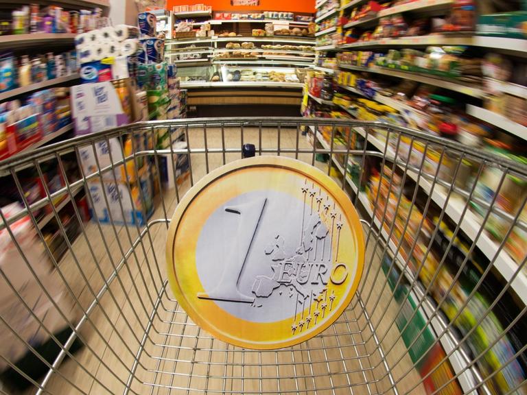 Eine überdimensionale Euromünze in einem Einkaufswagen