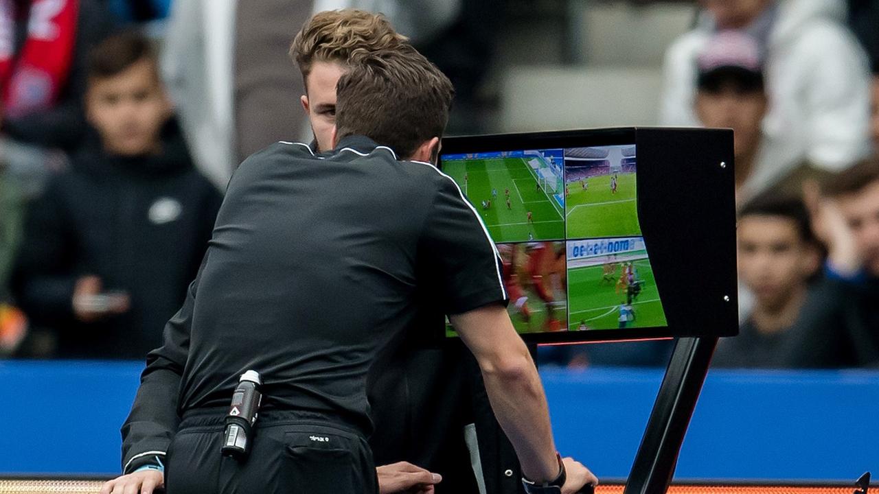 Schiedsrichter Harm Osmers zeigt den Videobeweis an und überprüft eine Elfmeter-Szene am Monitor. Schiedsrichter Harm Osmers zeigt den Videobeweis an und überprüft eine Elfmeter-Szene am Monitor.