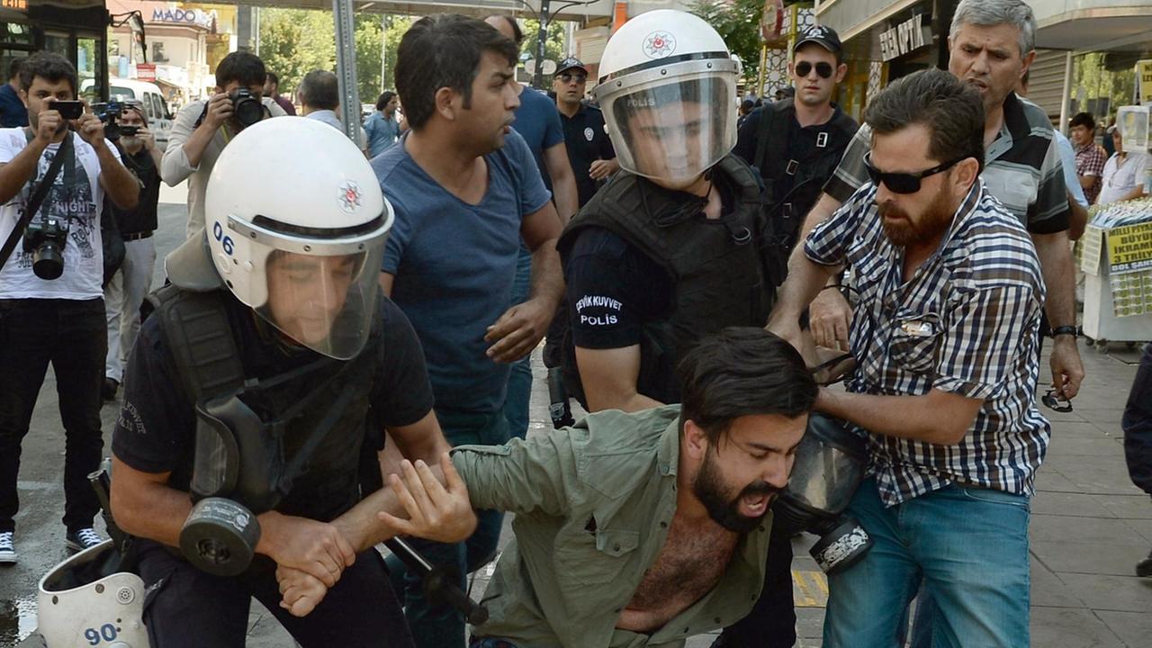 Polizisten halten am 23.07.2017 in Ankara (Türkei) einen Demonstranten fest, der zwei infahftierte Akademiker im Hungerstreik unterstützt. Sein Gesicht ist verzerrt vor Wut oder Schmerzen. Polizisten halten am 23.07.2017 in Ankara (Türkei) einen Demonstranten fest, der zwei infahftierte Akademiker im Hungerstreik unterstützt. Sein Gesicht ist verzerrt vor Wut oder Schmerzen.