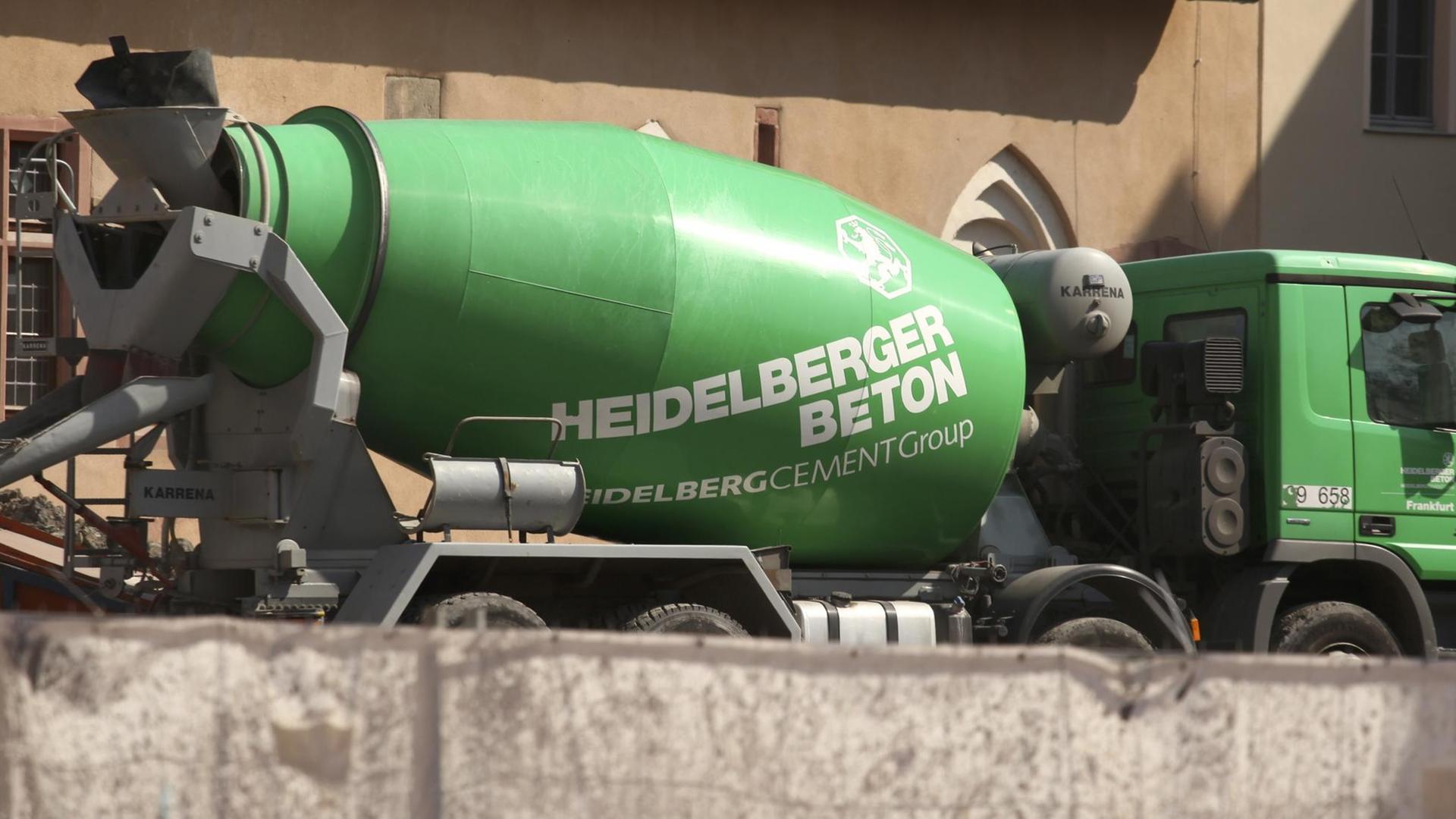 Ein Zementmischlaster mit der Aufschrift "Heidelberger Beton" des Weltunternehmens Heidelberger Zement steht an einer Baustelle Ein Zementmischlaster mit der Aufschrift "Heidelberger Beton" des Weltunternehmens Heidelberger Zement steht an einer Baustelle