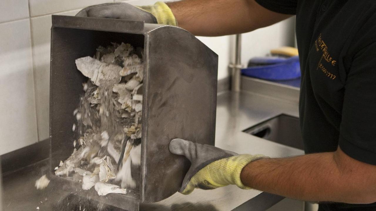 In einem Krematorium in Tirol werden die sterblichen Überreste einer Leiche von metallischen Gegenständen gesäubert. In einem Krematorium in Tirol werden die sterblichen Überreste einer Leiche von metallischen Gegenständen gesäubert.